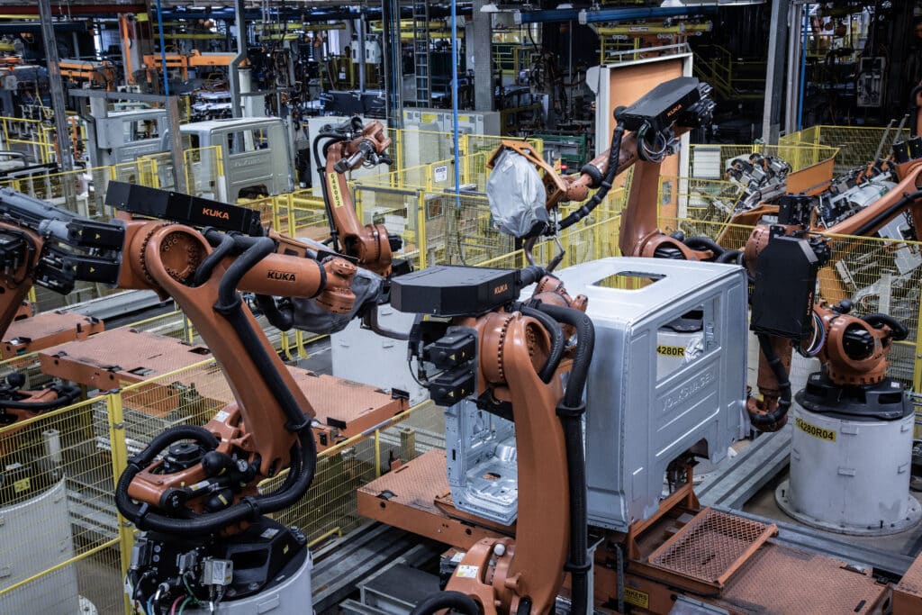 VWCO acelera digitalização e amplia robótica na produção Robôs industriais em fábrica automatizada durante processo de montagem